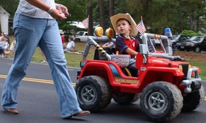 Colton Lee Johnson, 3, rolls down Free Union Road in his Jeep alongside his mother, Melissa, during the Patriot Parade in Free Union on Sunday, July 3 2005.